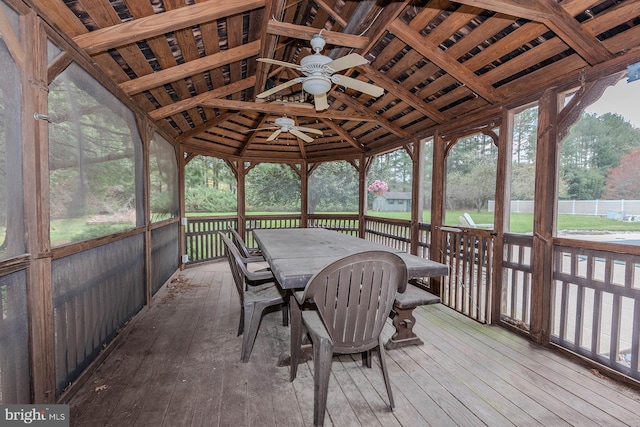 sunroom / solarium featuring a ceiling fan, plenty of natural light, and outdoor dining space