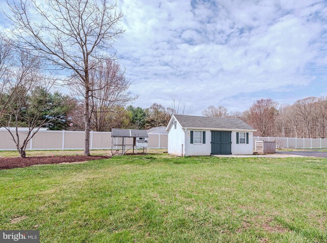 view of yard with an outbuilding and fence