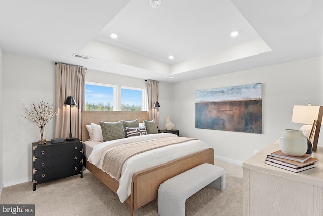 bedroom featuring baseboards, light carpet, recessed lighting, visible vents, and a raised ceiling