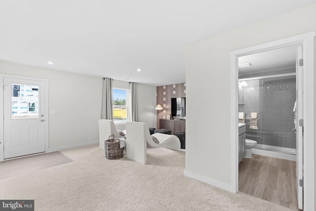 carpeted living area with baseboards, recessed lighting, and wood finished floors