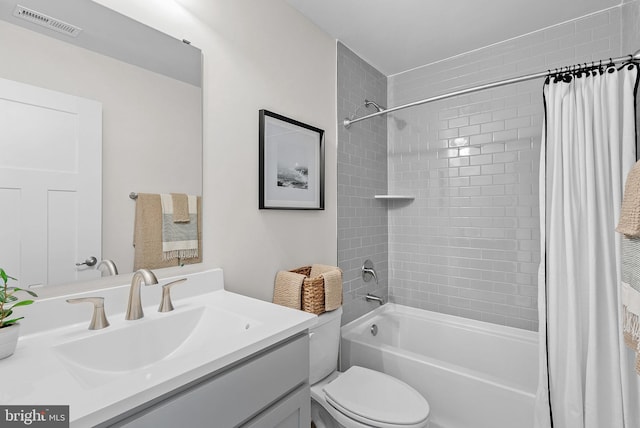 bathroom with toilet, vanity, shower / tub combo with curtain, and visible vents