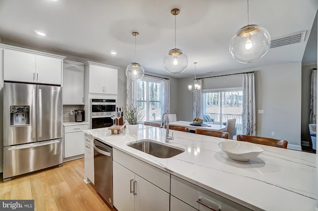 751 Bowie Shop Rd, Huntingtown, MD 20639 - kitchen with visible vents, light wood-style flooring, a sink, hanging light fixtures, and appliances with stainless steel finishes