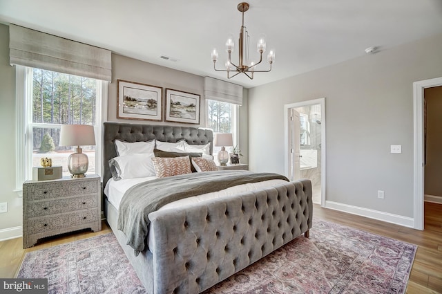 751 Bowie Shop Rd, Huntingtown, MD 20639 - bedroom featuring visible vents, a notable chandelier, ensuite bathroom, wood finished floors, and baseboards