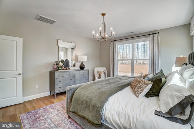 751 Bowie Shop Rd, Huntingtown, MD 20639 - bedroom featuring multiple windows, a notable chandelier, wood finished floors, and visible vents