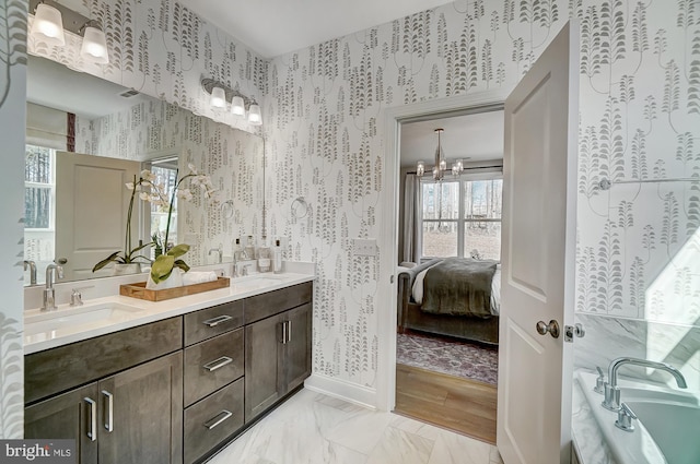751 Bowie Shop Rd, Huntingtown, MD 20639 - full bathroom featuring baseboards, wallpapered walls, an inviting chandelier, and a sink