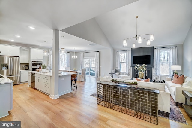 751 Bowie Shop Rd, Huntingtown, MD 20639 - living area featuring light wood-style flooring, a chandelier, and vaulted ceiling