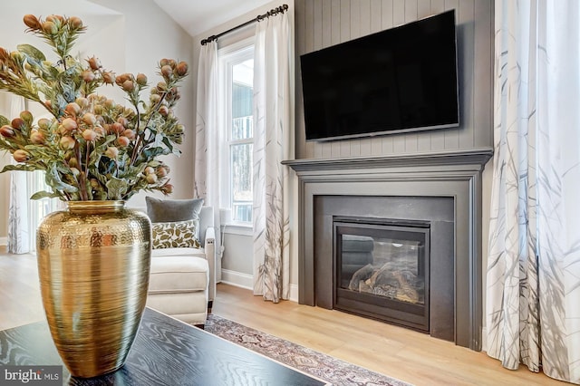 751 Bowie Shop Rd, Huntingtown, MD 20639 - living area with a glass covered fireplace, vaulted ceiling, wood finished floors, and baseboards