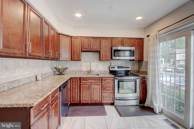 14613 Tynewick Ter Unit 6-1461, Silver Spring, MD 20906 - kitchen featuring a sink, brown cabinetry, stainless steel appliances, visible vents, and backsplash
