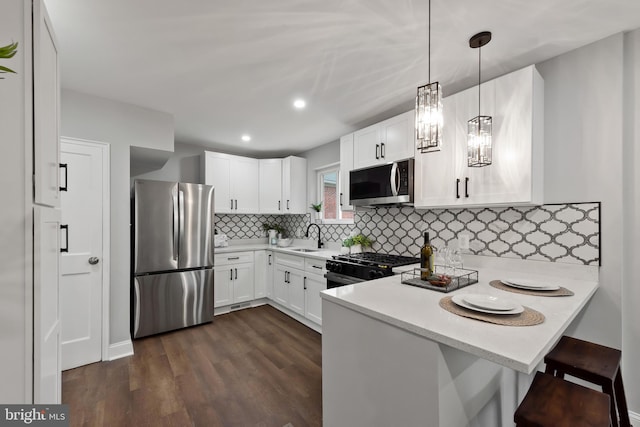 6611 Loch Hill Rd, Baltimore, MD 21239 - kitchen featuring stainless steel appliances, light countertops, a peninsula, white cabinets, and dark wood-style flooring