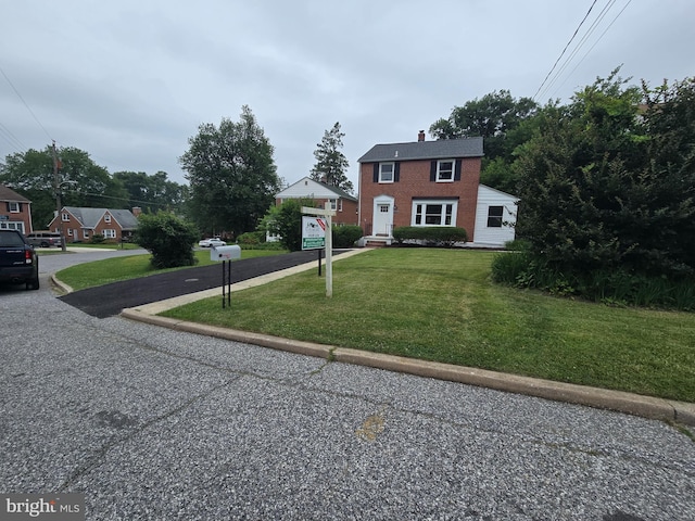 6611 Loch Hill Rd, Baltimore, MD 21239 - colonial inspired home featuring a front yard, a chimney, and brick siding