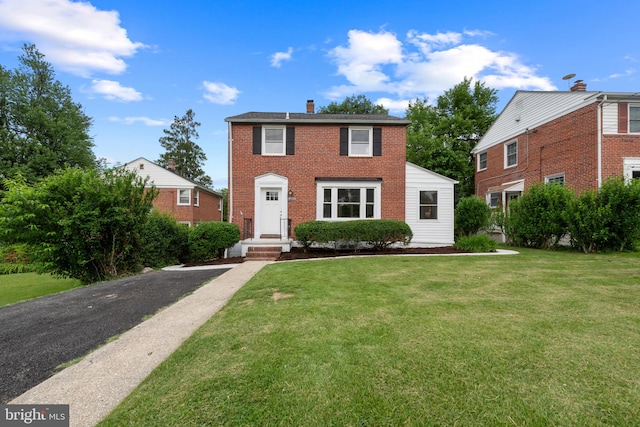 6611 Loch Hill Rd, Baltimore, MD 21239 - view of front facade with a chimney, brick siding, and a front yard