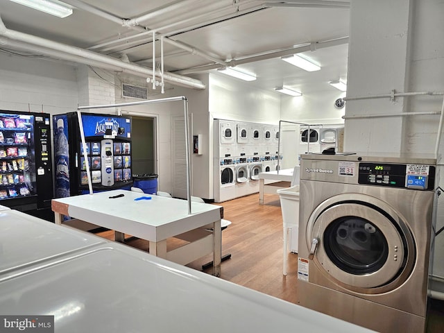 5340 Holmes Run Pkwy Unit 1410, Alexandria, VA 22304 - shared laundry room featuring stacked washer and clothes dryer, wood finished floors, and washer and clothes dryer