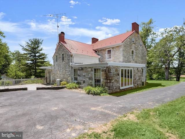 8805 Reichard Rd, Fairplay, MD 21733 - view of property exterior with stone siding, a chimney, metal roof, and a wooden deck