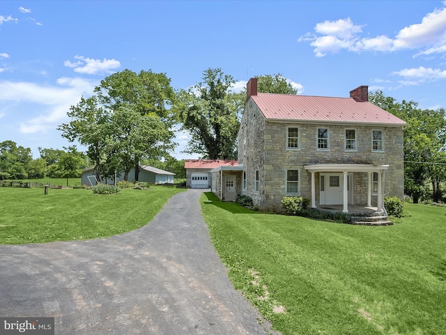 8805 Reichard Rd, Fairplay, MD 21733 - colonial inspired home with a chimney, stone siding, a front yard, and metal roof