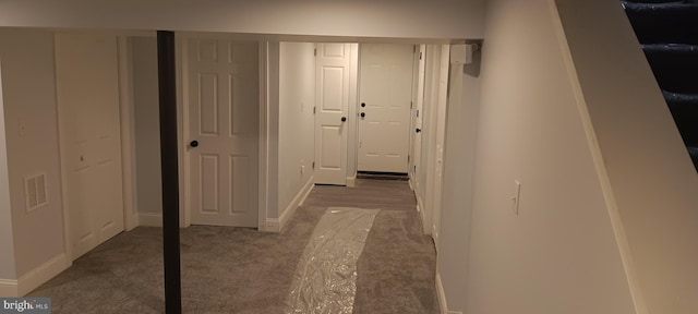hallway with carpet flooring, baseboards, and visible vents