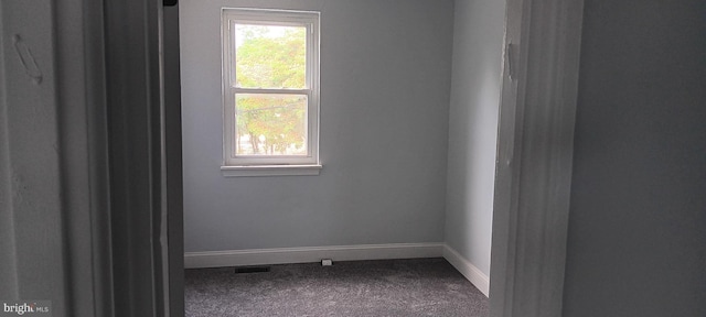 empty room with visible vents, baseboards, and carpet