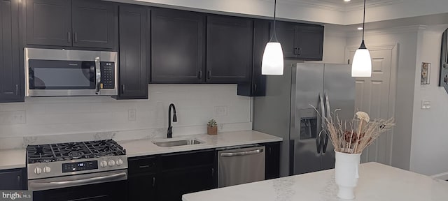 kitchen featuring a sink, appliances with stainless steel finishes, pendant lighting, dark cabinets, and backsplash