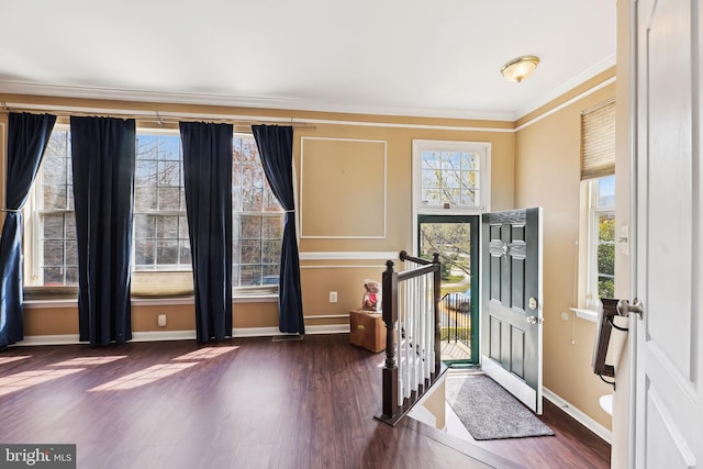 entrance foyer featuring crown molding, baseboards, and dark wood finished floors