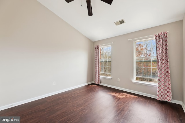 unfurnished room with ceiling fan, vaulted ceiling, visible vents, dark wood-style flooring, and baseboards