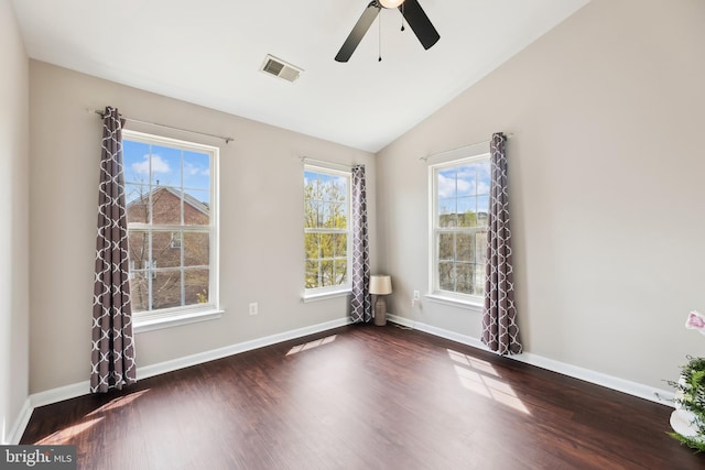 empty room featuring visible vents, baseboards, wood finished floors, and a healthy amount of sunlight