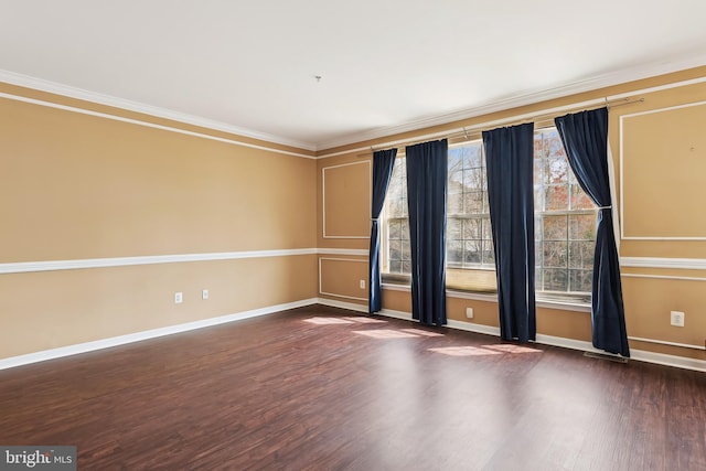 spare room with wood finished floors, baseboards, and ornamental molding