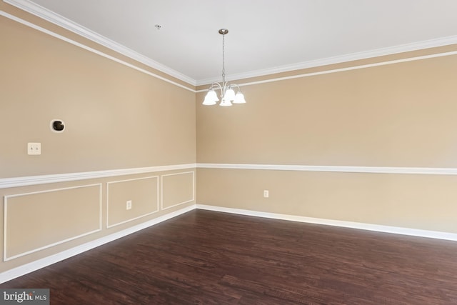 unfurnished room with crown molding, a decorative wall, an inviting chandelier, a wainscoted wall, and wood finished floors