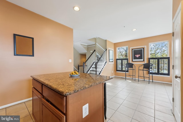 kitchen featuring light tile patterned floors, a center island, recessed lighting, and baseboards