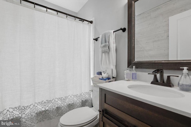 bathroom with curtained shower, toilet, and vanity