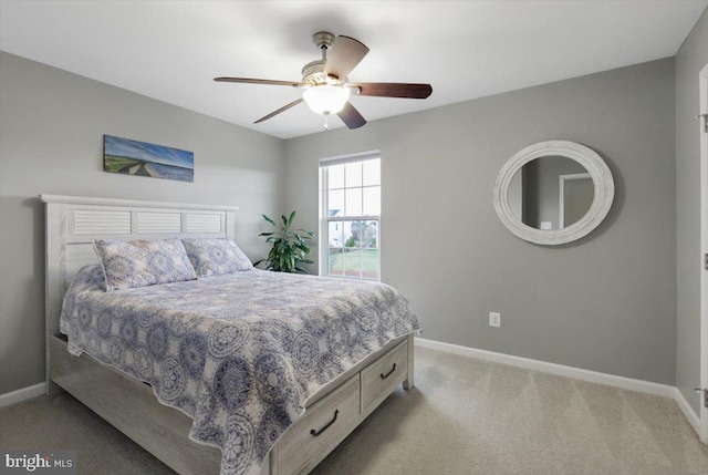 bedroom featuring light carpet, a ceiling fan, and baseboards
