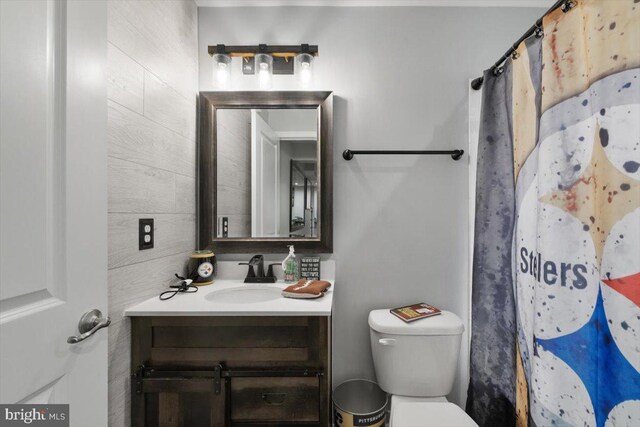 bathroom featuring curtained shower, toilet, and vanity
