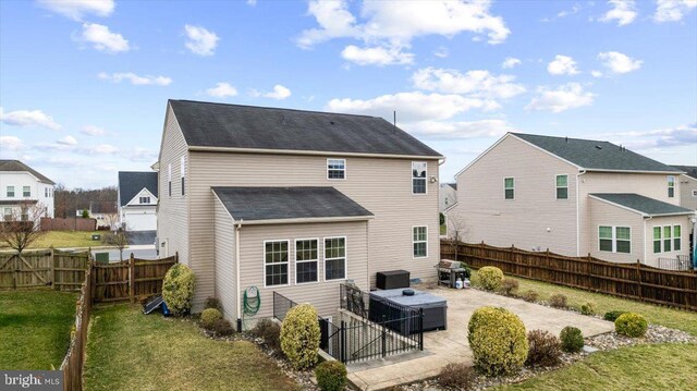 back of house with a yard, a shingled roof, a fenced backyard, and a patio area
