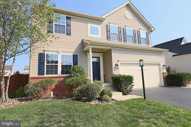 traditional home featuring brick siding, a front lawn, fence, aphalt driveway, and a garage