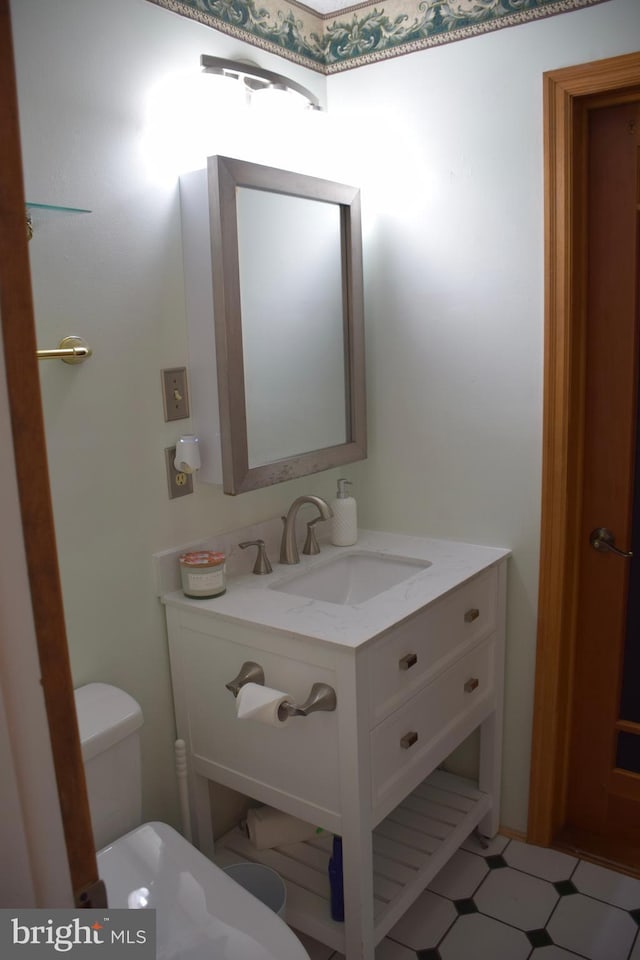 half bath with vanity, tile patterned floors, and toilet