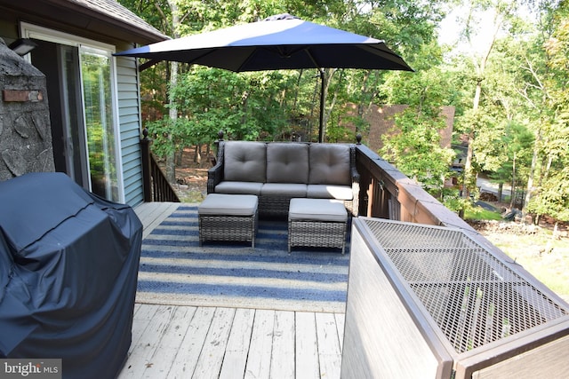 wooden terrace featuring area for grilling and an outdoor hangout area
