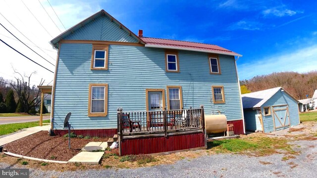 8354 Cumberland Rd, Springfield, WV 26763 - back of property featuring a chimney, heating fuel, and a wooden deck