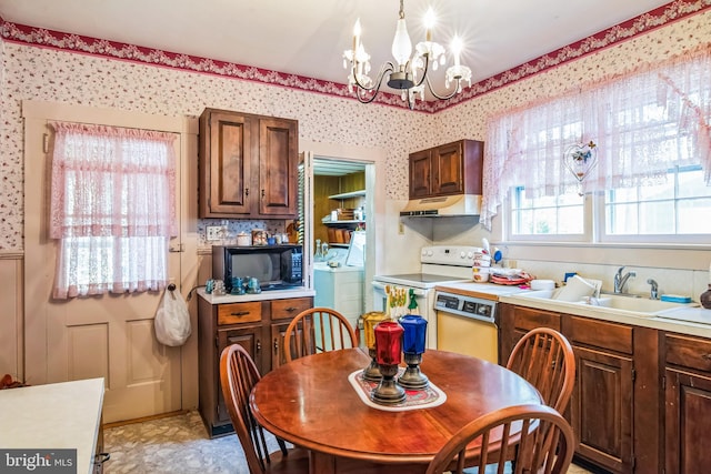 kitchen with under cabinet range hood, a sink, black microwave, wallpapered walls, and dishwashing machine
