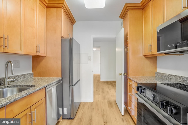 4101 Cathedral Ave NW Unit 1104, Washington, DC 20016 - kitchen with appliances with stainless steel finishes, a sink, light wood finished floors, light stone countertops, and baseboards