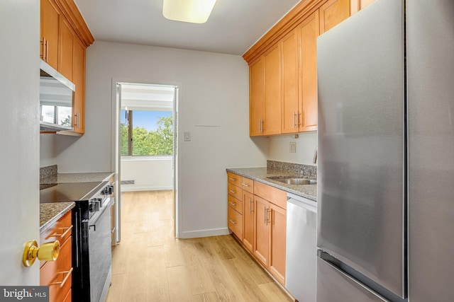 4101 Cathedral Ave NW Unit 1104, Washington, DC 20016 - kitchen featuring stainless steel appliances, a sink, light wood finished floors, light stone countertops, and brown cabinetry