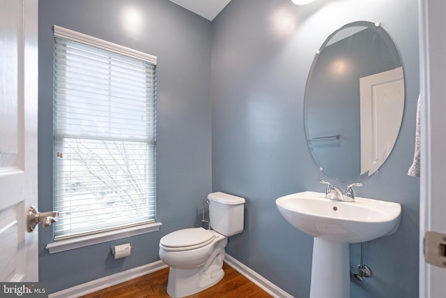 bathroom with baseboards, toilet, and wood finished floors