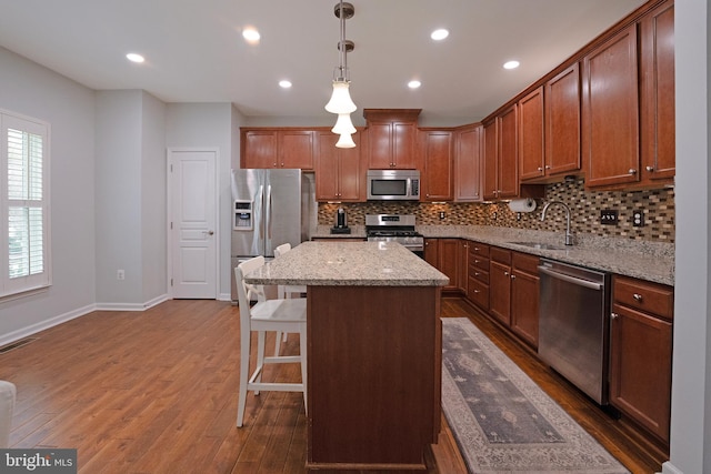 kitchen featuring dark wood-style floors, visible vents, decorative backsplash, stainless steel appliances, and a sink
