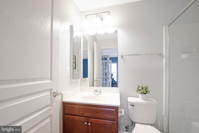 bathroom with toilet, vanity, and walk in shower