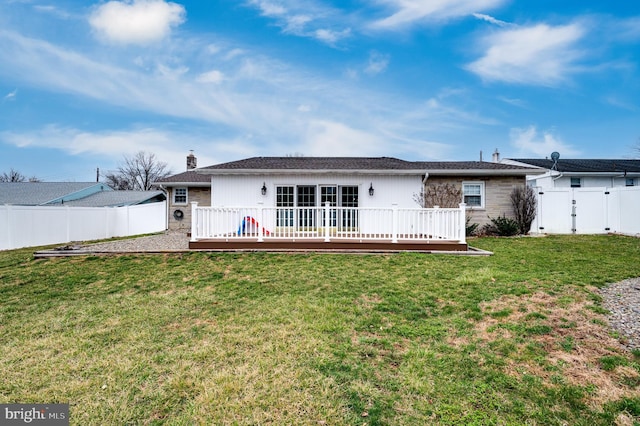 rear view of property featuring a yard, a wooden deck, a fenced backyard, and a chimney