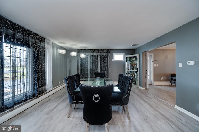 dining area with visible vents, baseboards, light wood-type flooring, and a baseboard radiator