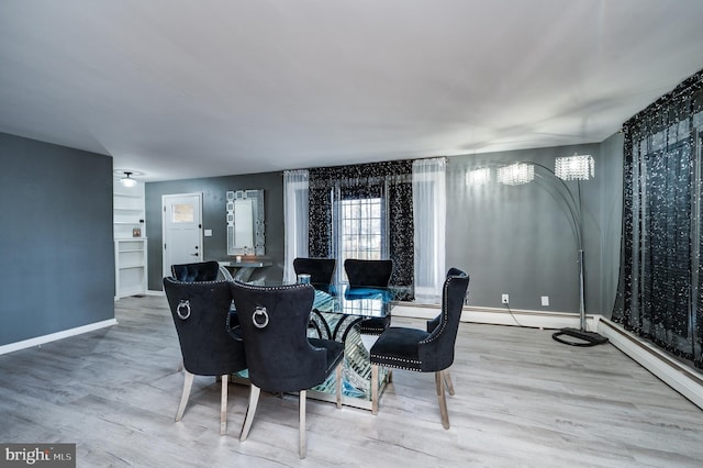 dining area with wood finished floors, baseboards, and a baseboard radiator