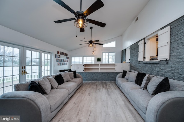 living area with a ceiling fan, visible vents, high vaulted ceiling, light wood-style flooring, and french doors