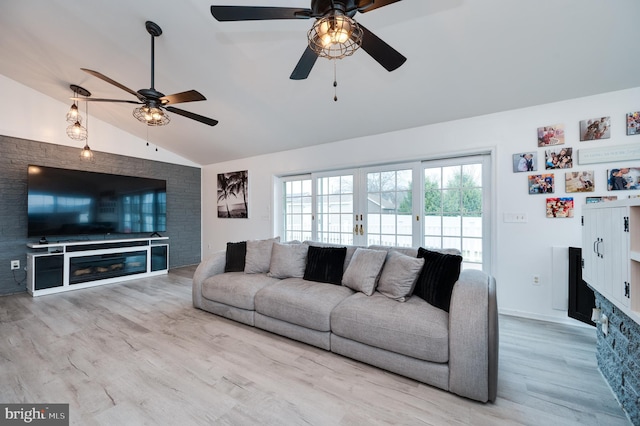 living area with a fireplace, wood finished floors, a ceiling fan, and vaulted ceiling