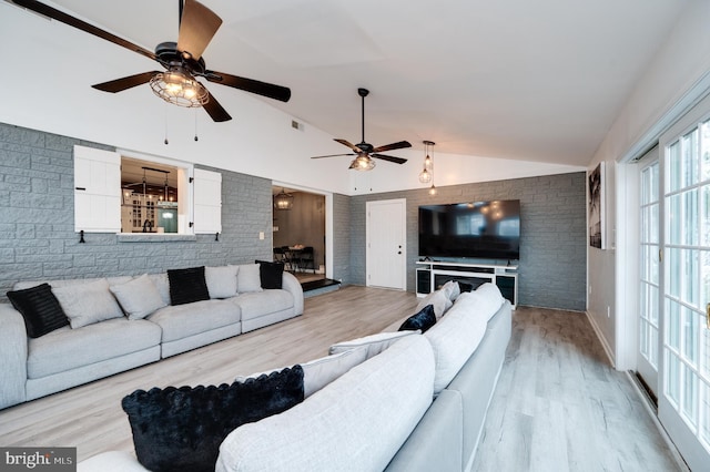 living room with a ceiling fan, lofted ceiling, and wood finished floors