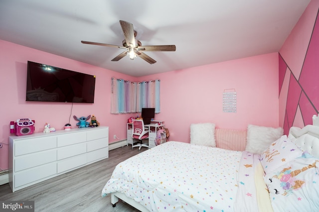 bedroom with ceiling fan, baseboard heating, and wood finished floors