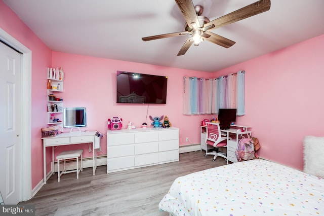 bedroom with wood finished floors, baseboards, a ceiling fan, a baseboard heating unit, and baseboard heating