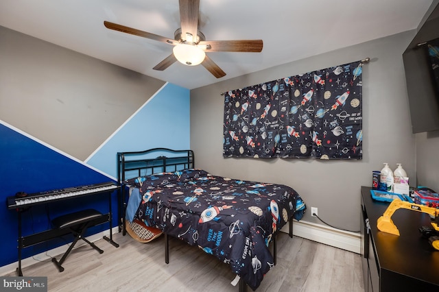 bedroom featuring wood finished floors, baseboards, baseboard heating, and ceiling fan